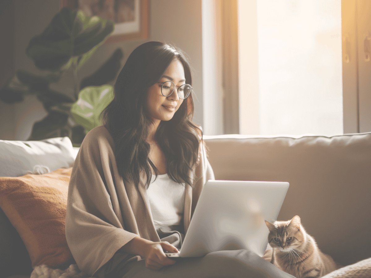 Social Media Reporting feature image woman and laptop on sofa with her cat